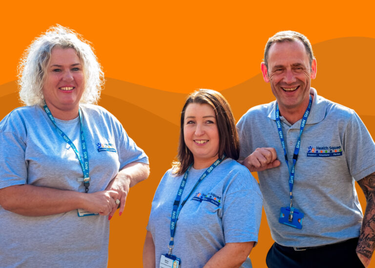 A group of 3 people (2 women and 1 man) who work for Health Squad, all in uniform smiling at the camera with a 3 toned orange background.