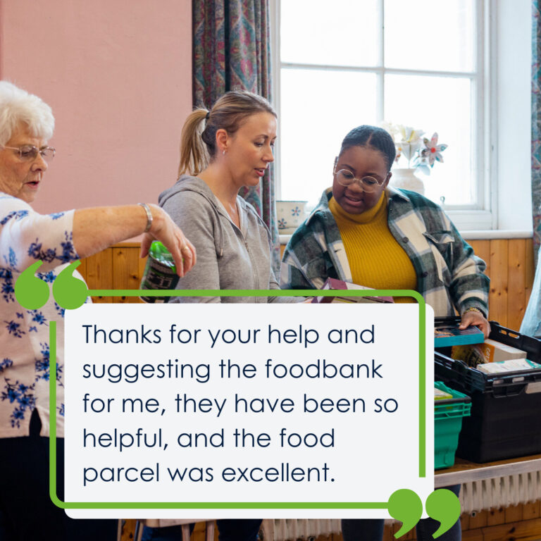 3 women in line at a foodbank looking at the various grocery items in the baskets. The quote on the picture says 'Thanks for your help and suggesting the foodbank for me, they have been so helpful, and the food parcel was excellent.'