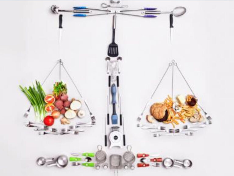 A picture of scales made out of kitchen utensils with fruit and veg on one side and burger and chips on the other.