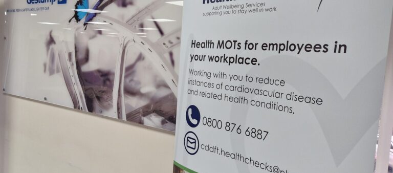 a sign on the wall promoting Health MOTs in the workplace