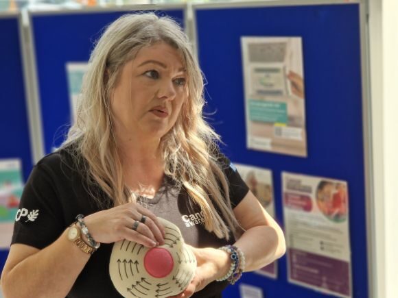 Andrea from Cancer Awareness demonstrating a self-check for breast cancer