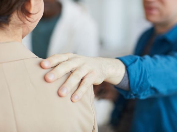 Supportive hand on a woman's shoulder