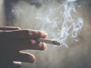 A lit cigarette in a person's hand