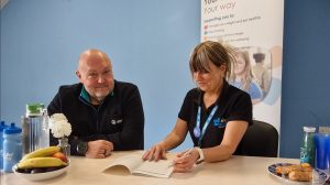 Chris and Sharon chatting and reviewing one of the Wellbeing for Life Eatwise session booklets.